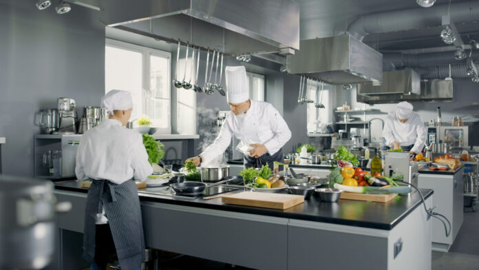 Big and Glamorous Restaurant Busy Kitchen, Chefs and Cooks Worki